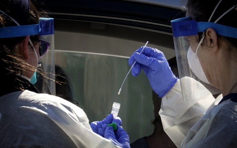 Image: Health care workers administer a coronavirus test at a drive-thru testing site for children in Washington, D.C., on April 2, 2020.