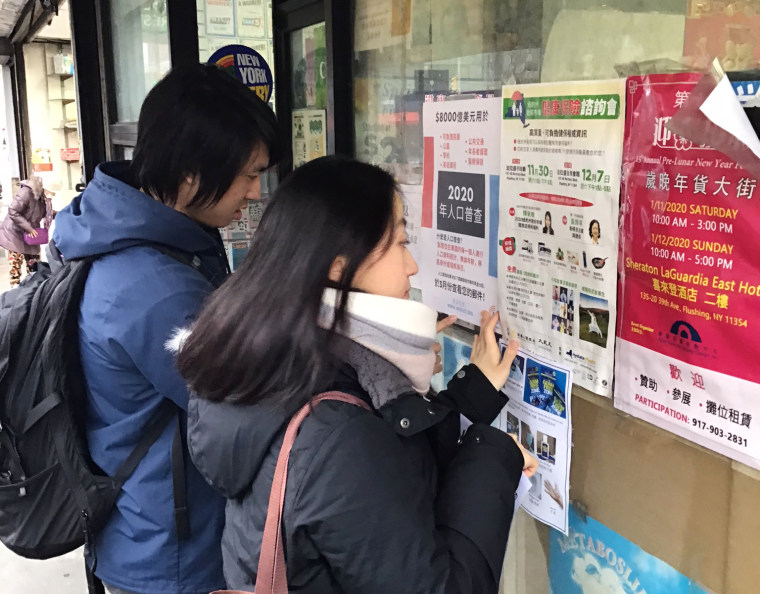 MinKwon census outreach staff Fred Liu and Shiza Ranamagar hang Chinese and Korean language posters at stores last month in Flushing, N.Y.