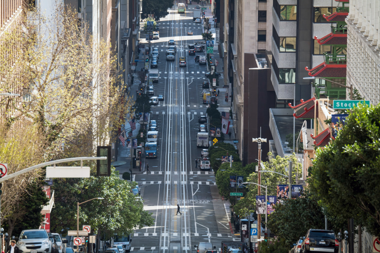 Image: A pedestrian crosses an empty California Street during rush hour in San Francisco