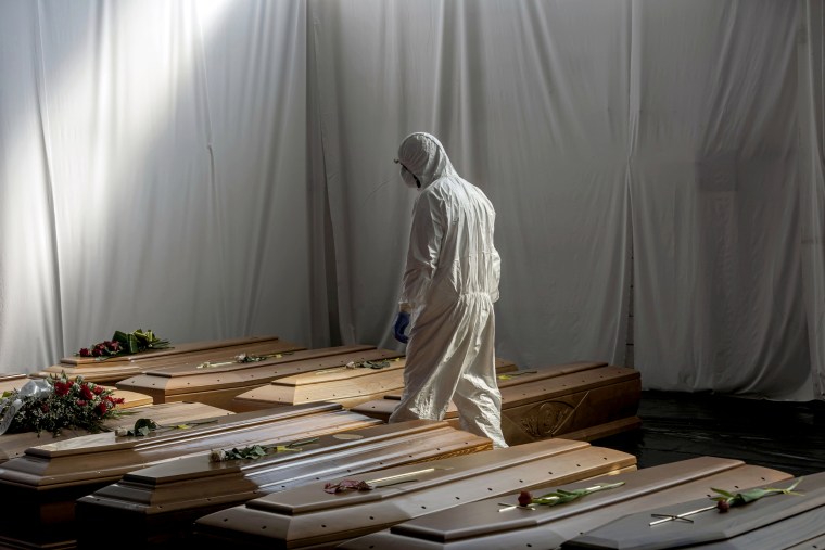 Image: The coffins of people who died from coronavirus wait to be transported from Bergamo to Florence for cremation on April 7, 2020.
