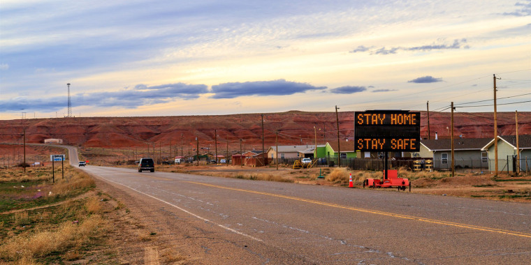 A sign in Many Farms, Ariz., tells Navajos to stay home as the tribal nation experiences an increasing number of coronavirus cases.