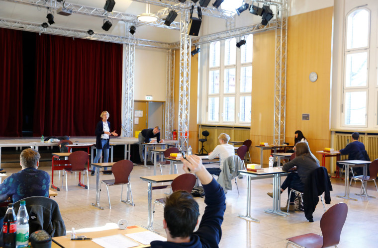 Image: A teacher welcomes students before the start of their high school graduation exams, during the spread of the coronavirus disease (COVID-19), at the Gymnasium Steglitz school in Berlin