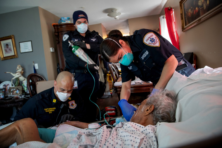 Image: Medics prepare to intubate a patient showing COVID-19 symptoms at his home in Yonkers, N.Y., on April 6, 2020.