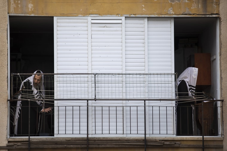 Image: Ultra-Orthodox Jews pray a morning prayer at their house as synagogues are closed following the government's measures to help stop the spread of the coronavirus, in Bnei Brak,