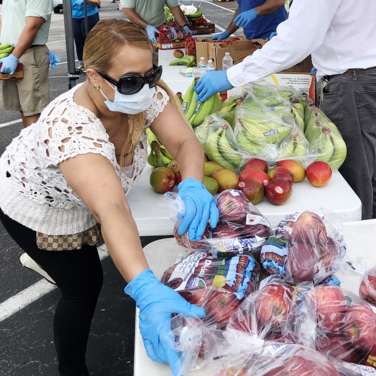 Volunteers distribute food at an event by Food Share in Doral, Fla.,on April 17, 2020.