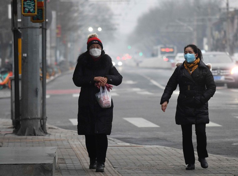 Image: Women wear face masks to protect against COVID-19 on a polluted day in Beijing
