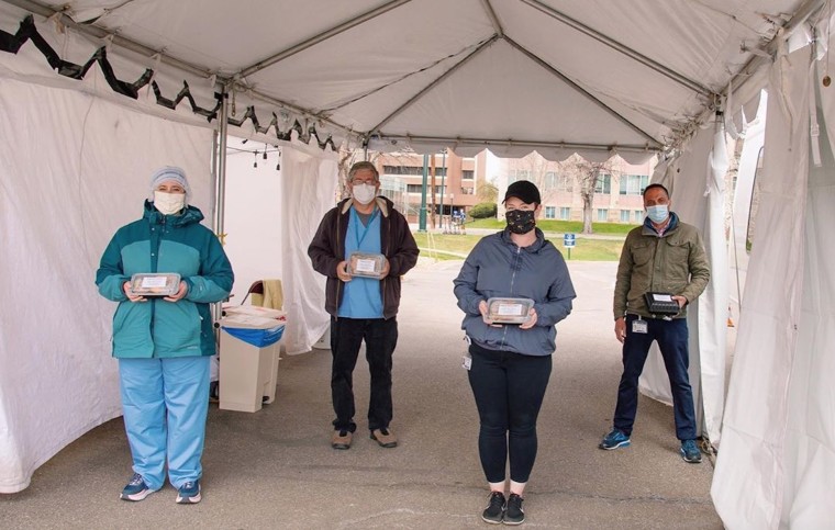 Hospital workers practice social distancing while receiving meals from Frontline Foods.