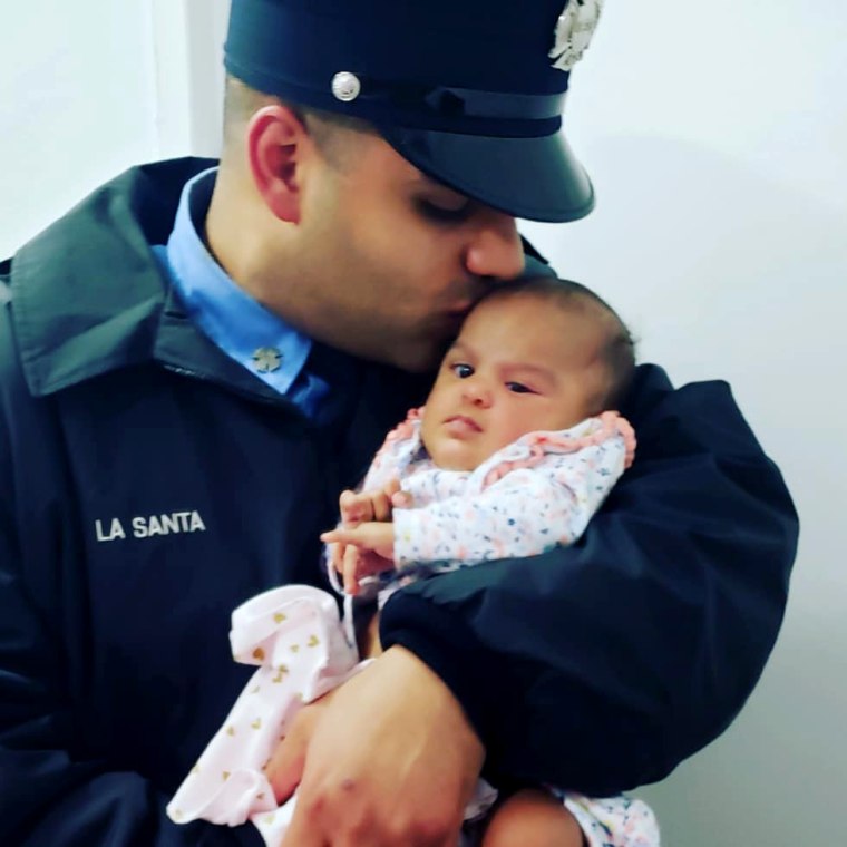 Image: Jerel La Santa holds his daughter, five-month-old Jay-Natalie.