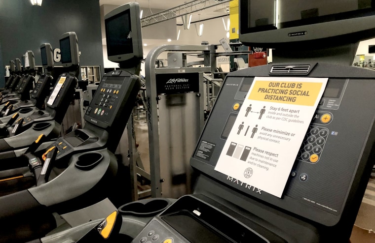 A gym preparing to reopen in Georgia with social distancing signs on the equipment.