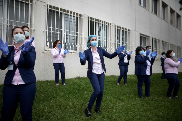 Staff members dance outside a hospital in Byblos as a band plays to thank them for their efforts Thursday. 
