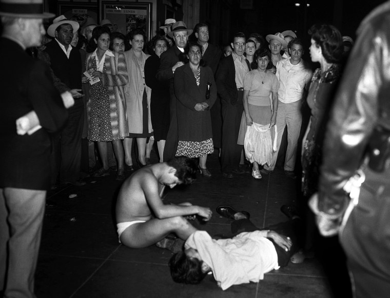 Two young men, one stripped of all his clothes, the other badly beaten, by policemen, in Los Angeles on June 7, 1943. Fifty or more zoot suiters had their clothing torn from them, police reported.