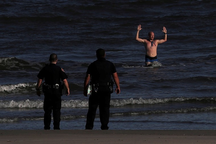 Image: Man exits Galveston Beach with arms raised during coronavirus disease (COVID -19) pandemic in Galveston, Texas