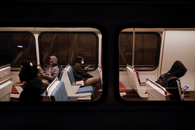 A passenger looks at her cell phone while riding in a Metro train car, as Mayor Muriel Bowser declared a State of Emergency due to the coronavirus disease (COVID-19), at the Metro Center underground train station in Washington