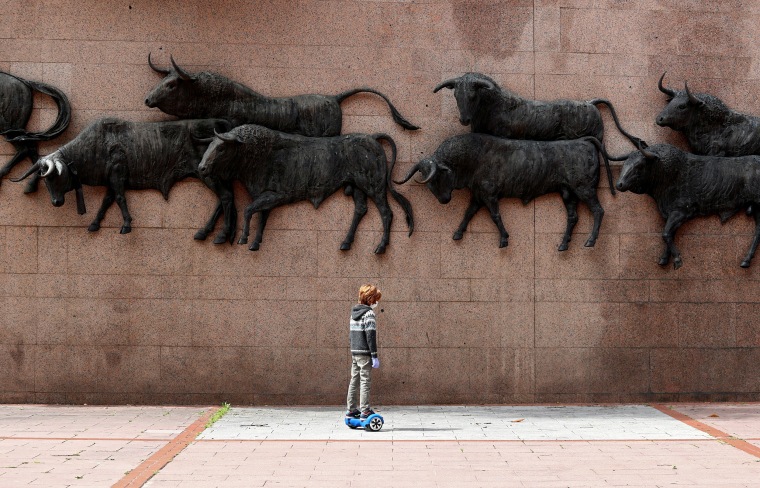 Image: A child on a hoverboard past the bulls sculptures outside Las Ventas bullring, after restrictions were partially lifted for children for the first time in six weeks, following the coronavirus disease (COVID-19) outbreak in Madrid,