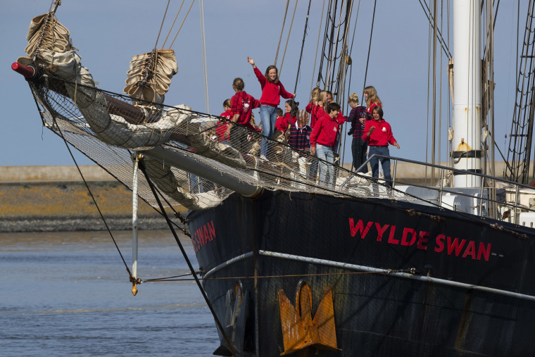 Image: Dutch teens cheer on their schooner Wylde Swan after sailing home from the Caribbean across the Atlantic when coronavirus lockdowns prevented them flying, in the port of Harlingen, northern Netherlands