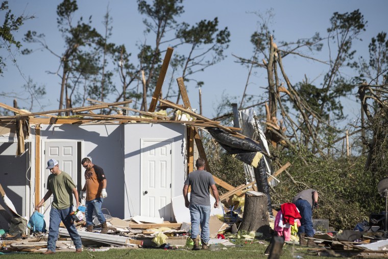 Residents sift through the rubble of a home on April 23, the day after a tornado ripped through the area in Onalaska, Texas.