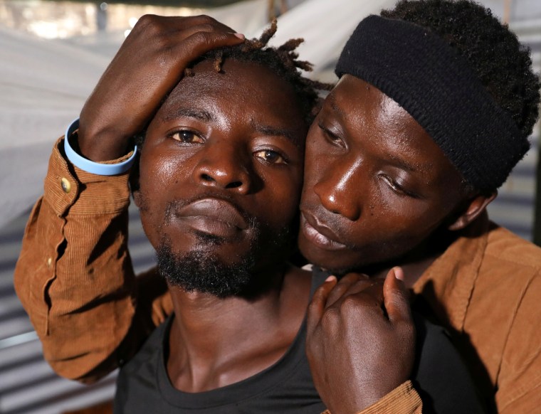 Ugandan refugees Kimuli Brian and Dennis Wasswa, members of the LGBT community, embrace each other inside their shelter at the Kakuma refugee camp, in Turkana county