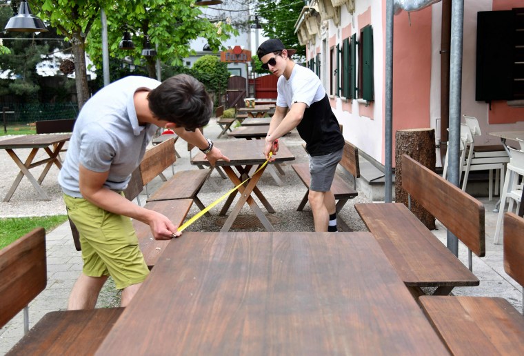 Image: Staff at the FuxnGut restaurant measure distance between tables as they prepare their premises for reopening in Salzburg, central Austria