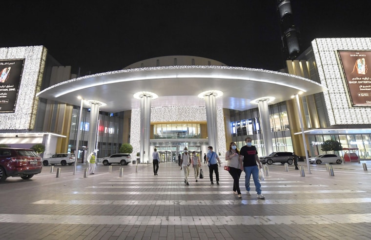 Image: People wearing masks for protection against the coronavirus, leave the Mall of Dubai