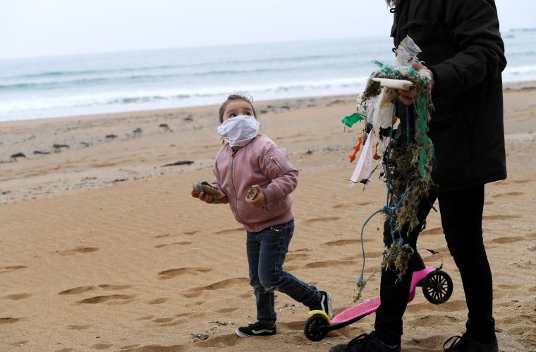 Image: Alexandre and his daughter Alejandra go for a walk and collect plastic along the beach after the restrictions for children were partially lifted for the first time in six weeks during the outbreak of coronavirus disease (COVID-19) in Gijon