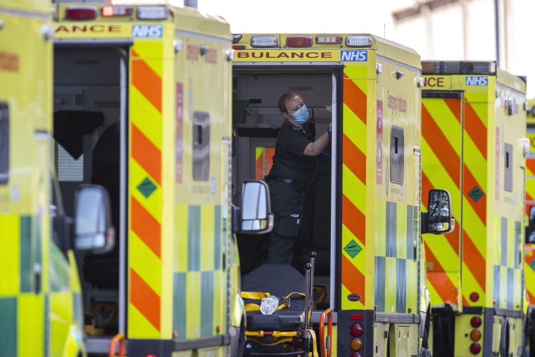 Image: A London Ambulance worker cleans an ambulance outside of the Royal London Hospital