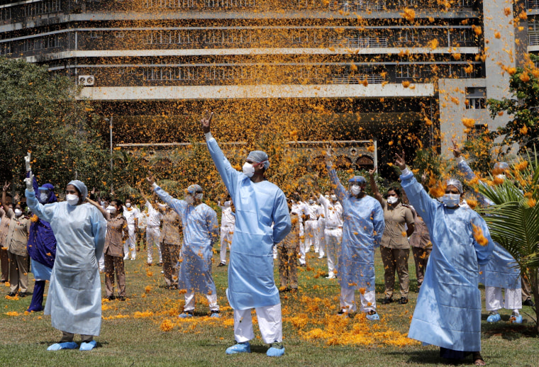 Image: An Indian Air Force helicopter showers the staff of Mumbai's INS Asvini Hospital with flower petals in a show of appreciation on May 3, 2020.