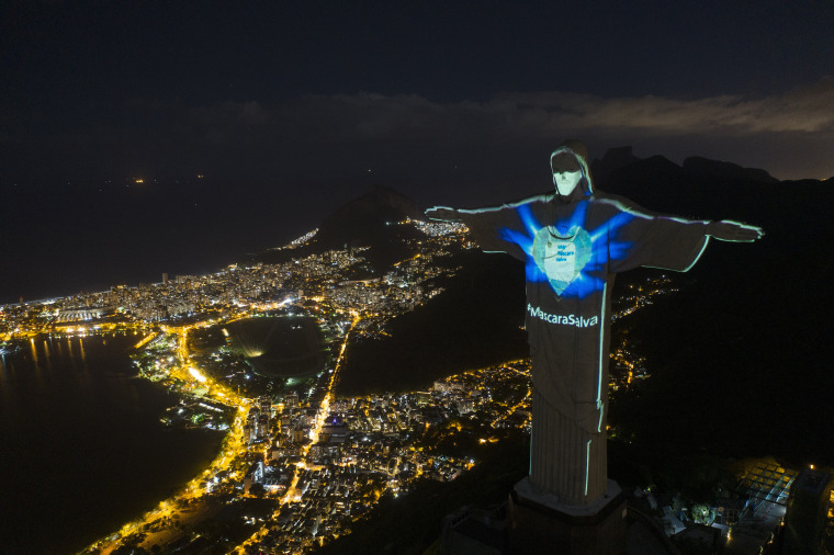 The Christ the Redeemer statue in Rio de Janeiro is lit up as if wearing a protective mask amid the coronavirus pandemic on Sunday. The message "Mask saves" is written in Portuguese.