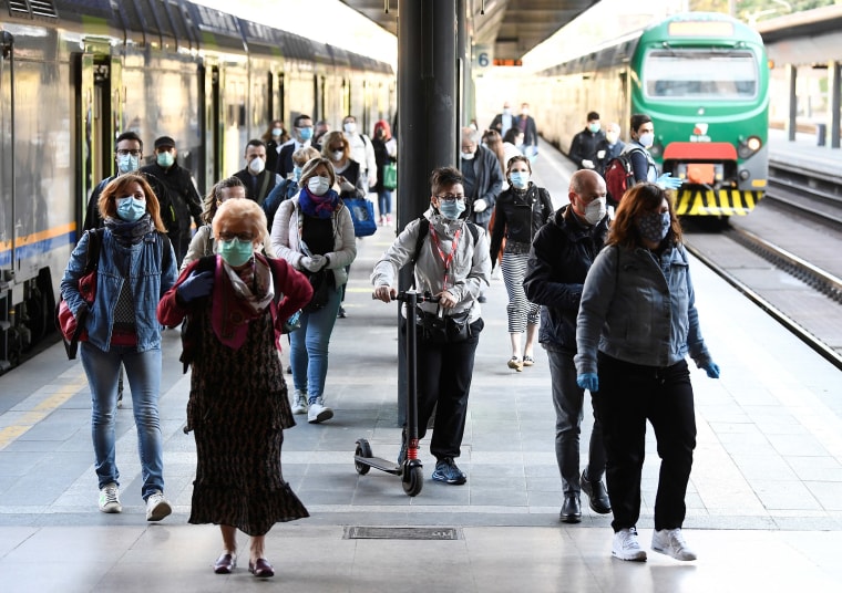 Image: People wearing face masks arrive at the Cadorna railway station, as Italy begins a staged end to a nationwide lockdown due to the spread of the coronavirus disease (COVID-19), in Milan,