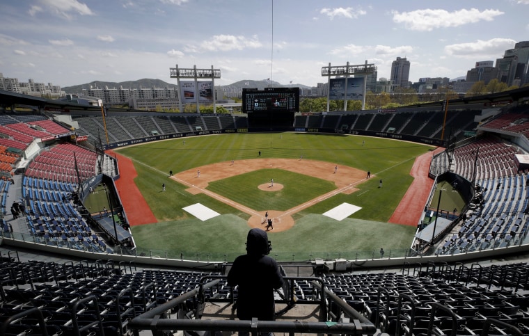 Image: A cameraman films a pre-season baseball game between the Doosan Bears and LG Twins in Seoul on April 21, 2020. South Korea's baseball season will begin on May 5 without fans.