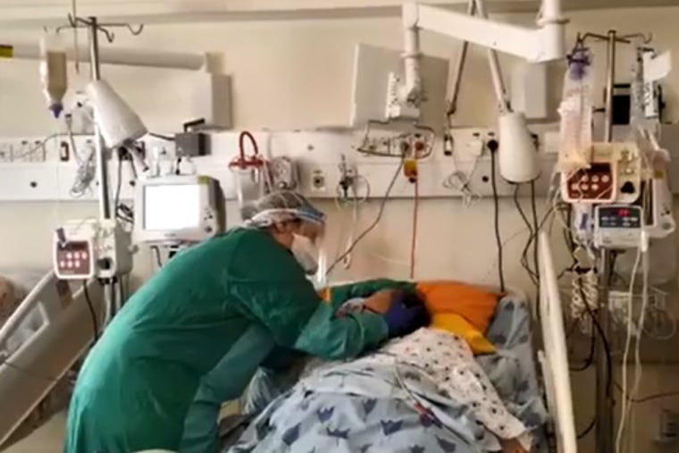 Image: Rinat Vita Dishlo says goodbye to her mother, Vita Bat Sheva, dying of coronavirus at Tel Aviv Sourasky Medical Center in Israel.