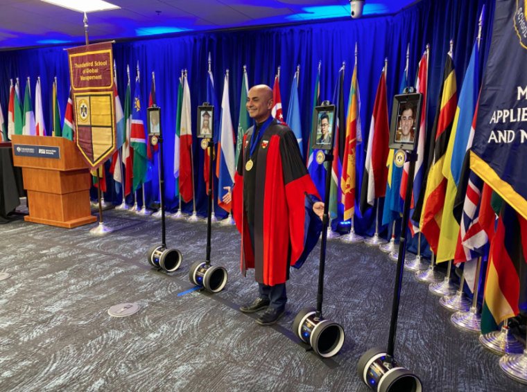 Image: The Thunderbird School of Global Management will use remote controlled robots to allow students to walk into their graduation ceremony, seen here in a practice run.