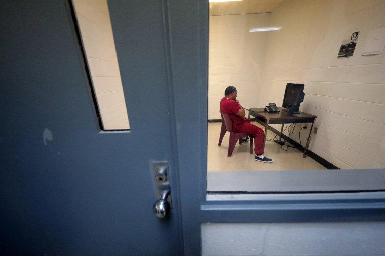 A detainee sits in a room to use a telephone inside the Winn Correctional Center in Winnfield, La., on  Sept. 26, 2019.