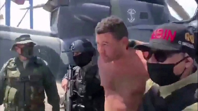 Image: Venezuelan soldiers in balaclavas move a suspect from a helicopter after what Venezuelan authorities described was a "mercenary incursion", at an unknown location in this still frame obtained from Venezuelan government TV video