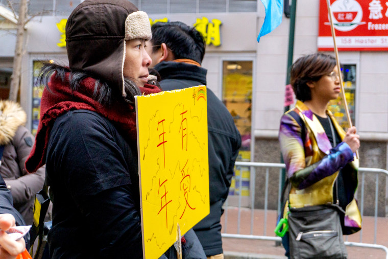 Manni Lee, one of the leaders of Grace Alive Fellowship, holds a sign during the Lunar New Year march in New York on Feb. 9, 2020.