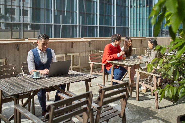 Businessman and friends sitting at table in cafe