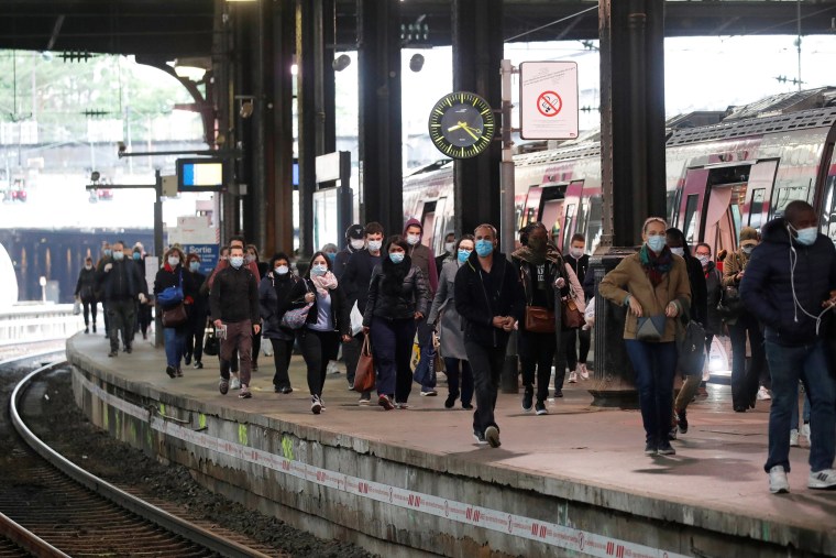 Image: Commuters, wearing protective face masks, walk on a platform at the Saint-Lazare train station in Paris, on the first day mask usage is mandatory in public transport, after France begun a gradual end to a nationwide lockdown due to the coronavirus
