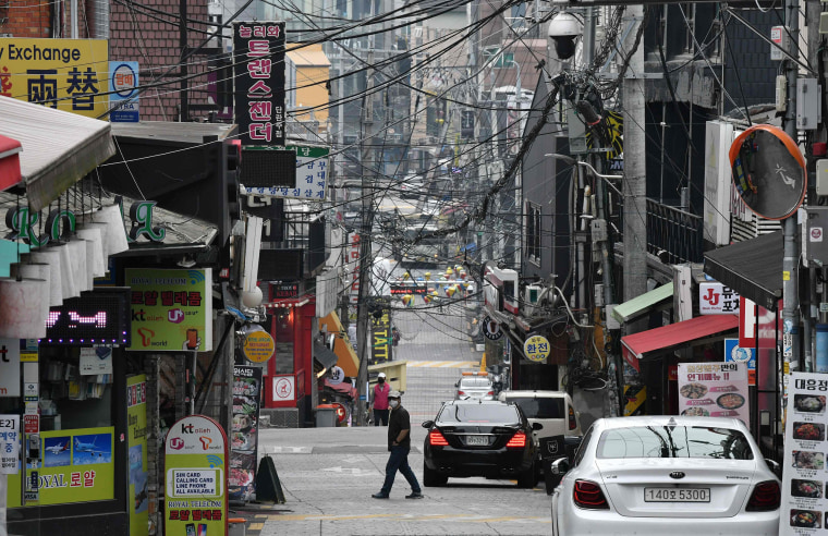 Image: A man wearing a face mask walks in the popular nightlife district of Itaewon in Seoul on May 10, 2020.