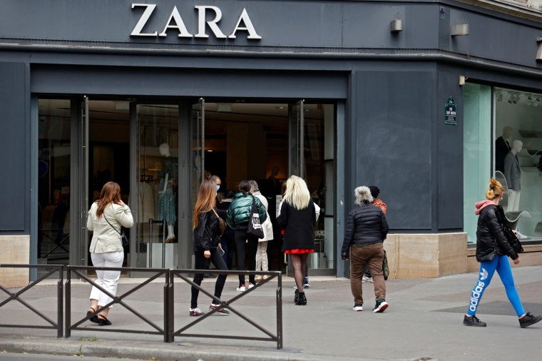 Image: Clients enter a Zara clothes shop in Paris on May 11, 2020 on the first day of France's easing of lockdown measures in place for 55 days to curb the spread of the COVID-19 pandemic