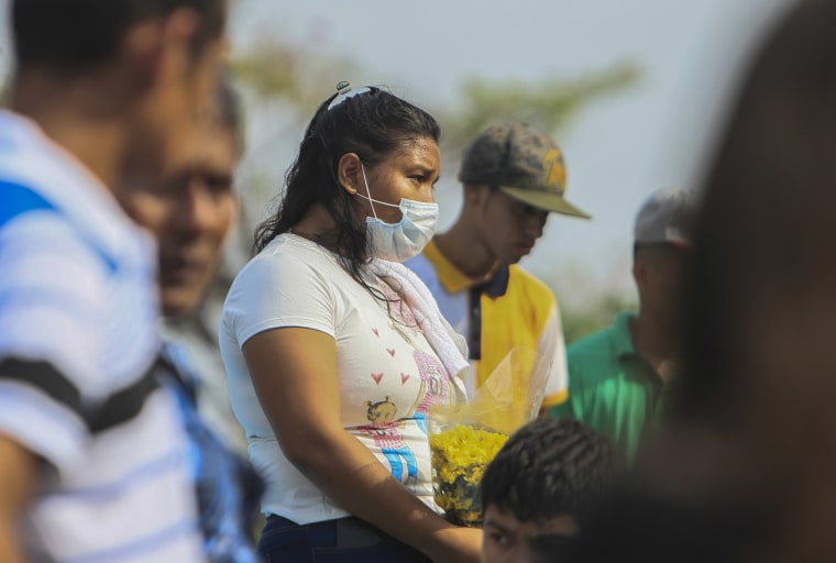 Image: A woman wears a mask against the spread of COVID-19 disease, as she attends a funeral at the Central cemetery of Managua, Nicaragua