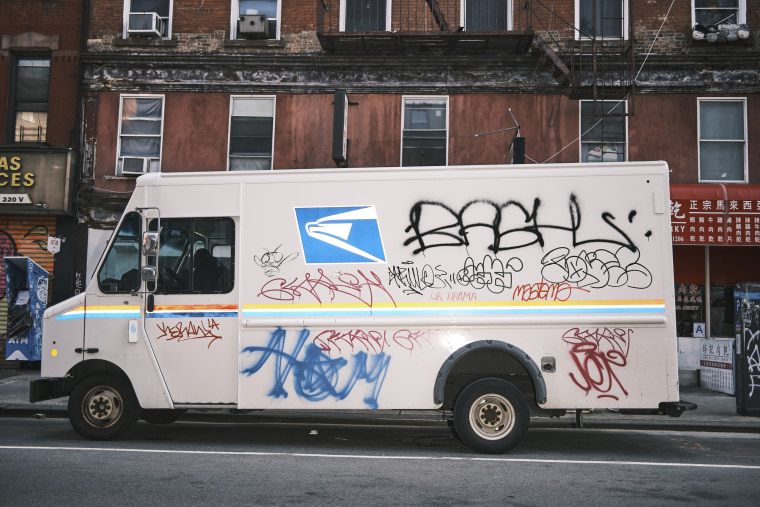 A USPS truck covered with tags on Canal Street in Chinatown.