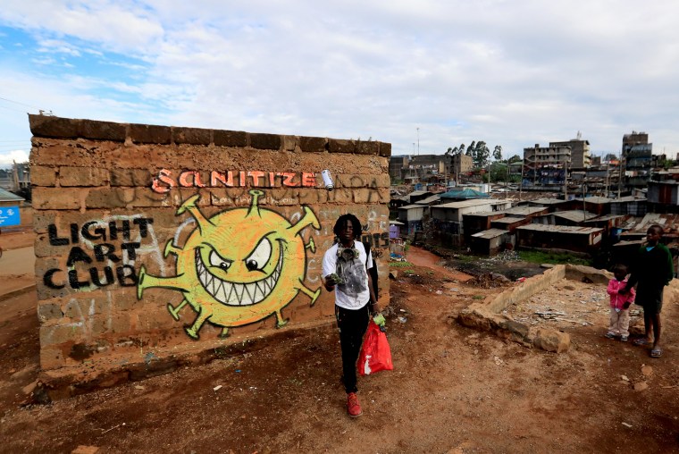 Image: Brian Musasia Wanyande, an artist from the Mathare Roots's youth group, walks after painting an advocacy graffiti against the spread of the coronavirus disease (COVID-19), at the Mathare Valley slum, in Nairobi