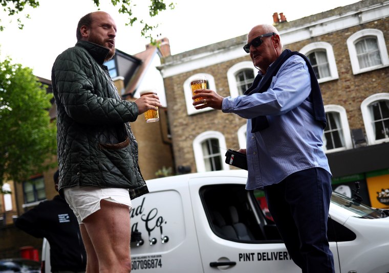 Image: Customers drink freshly poured pints of beer from the Forest Road Brewing Co "pub on wheels" van during its delivery round in east London.