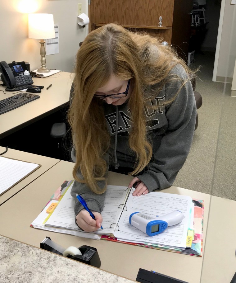 Image: Shelter crisis advocate Karissa Hobbs prepares to complete daily temperature checks of shelter residents at Safe House for Women in Cape Girardeau, Missouri.