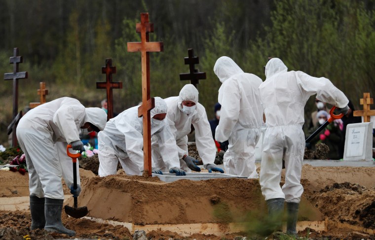 Image: Grave diggers bury a coronavirus disease victim in Saint Petersburg