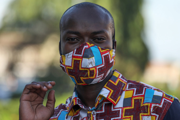 Image: Arthur Bella N'guessan, an Ivorian designer, looks on as he wears a protective face mask with colors matching his clothes, amid the coronavirus disease (COVID-19) outbreak, in Angre area of Abidjan, Ivory Coast
