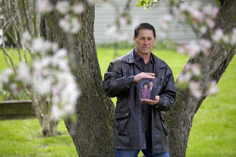 Paul Stewart holds a photo of his parents, Dolores and Robert Stewart, outside his home in Winfield, Ill.