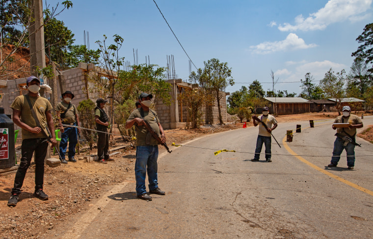 Community police in the mountain region of Malinaltepec in Mexico's Guerrero state maintain a roadblock to prevent the spread of COVID-19.
