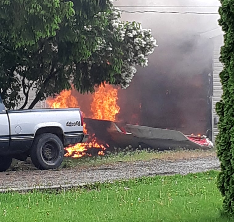 Image: Flames and debris at the site of the plane crash.