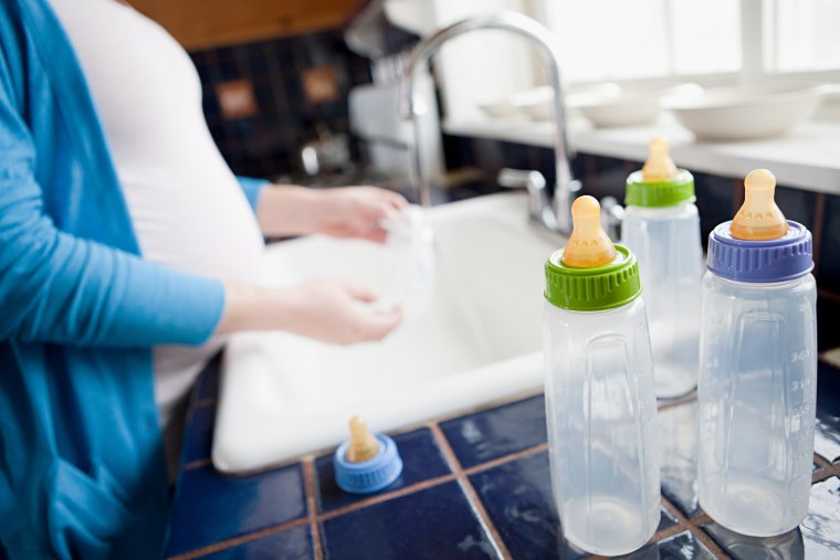Pregnant woman washing baby bottles