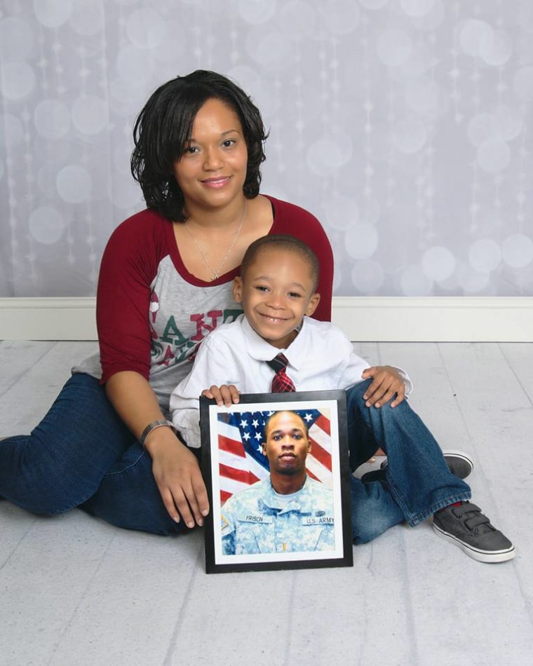 Mikki Frison and her son, Chris Frison, are pictured holding a photo of late husband and dad Demetrius Frison.